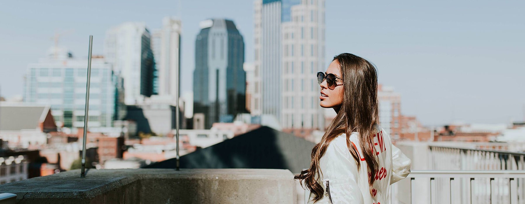 a person standing with a rooftop with a view of a city